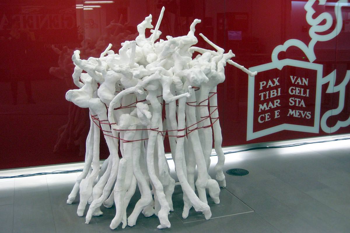 Weiße organische Skulptur vor roter Wand