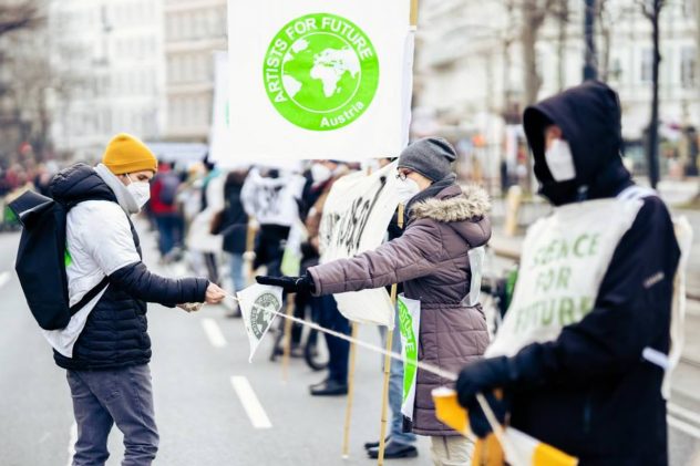 Menschen mit Plakaten bei Klimastreik artist for future