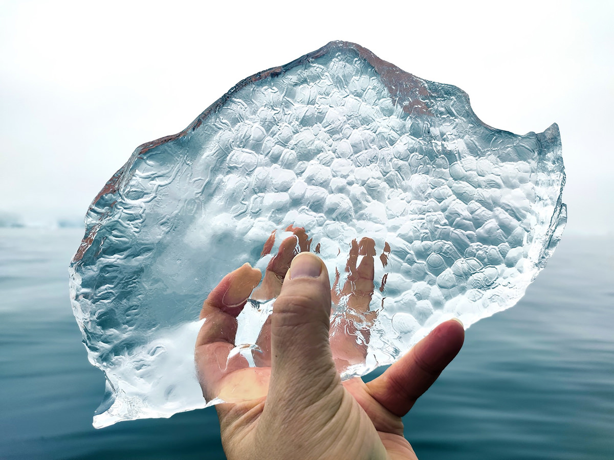 Hand hält ein Eisstück