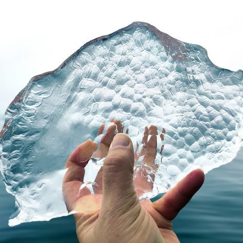 Hand hält ein Eisstück